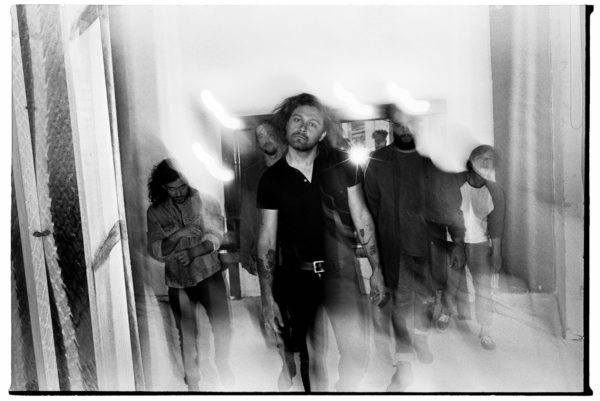 A motion-blurred shot of Gang Of Youths, with David Le'aupepe staring down the camera.