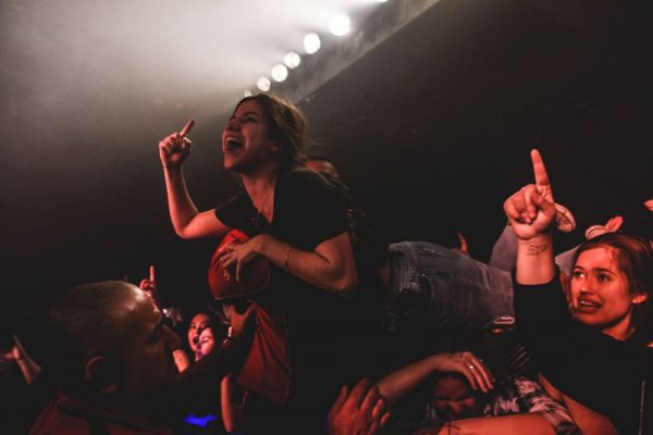 Security collect a female crowdsurfer at With Confidence's Factory gig